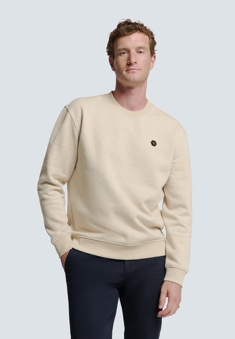 Beige crewneck sweatshirt van katoen, met een klein zwart hexagonaal logo op de linkerkant van de borst en ribgebreide manchetten en onderkant.