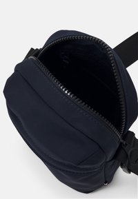 Borsa in nylon blu navy con apertura con zip, dotata di una tasca frontale, design elegante e tracolla regolabile per un uso versatile.