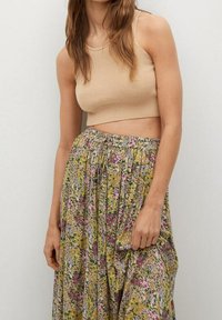 Béžový žebrovaný crop top spárovaný s květinovou maxi suknią s vzory v zelené, žluté a růžové barvě, s elastickým pasem a plisovaným designem.