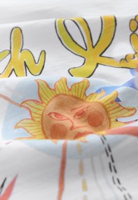 Bavlnená látka s farebným grafickým motívom slnka s tvárou, začleneným do výrazných žltých nápisov a abstraktných tvarov.