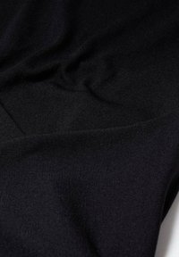 Tissu noir à texture lisse et mate, présentant une légère élasticité et des plis, mettant en valeur un design simple et classique.