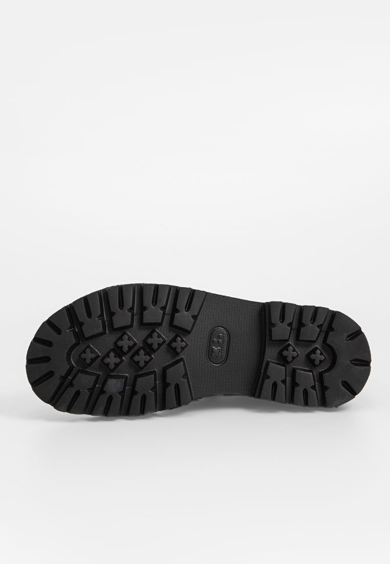 Semelle en caoutchouc noir avec des gommes profondes pour l'adhérence, dotée d'une surface lisse et d'un logo central. Conçu pour la durabilité et l'adhérence.