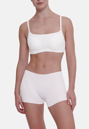 Witte naadloze bh met lichte padding en verstelbare bandjes, gecombineerd met bijpassende witte boyshort onderbroek, beide gemaakt van een soepel materiaal.