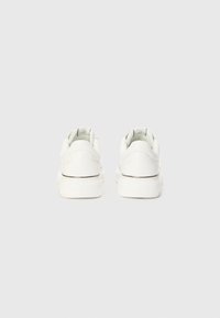 Sneaker bianche con tomaia in pelle liscia, punta rotonda, collo imbottito e suola in gomma. Design minimalista con un branding sottile sul tallone.