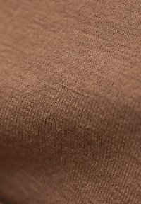 Bruine gebreide stof met een zachte textuur en strakke weving. Heeft een subtiel, uniform patroon en een lichte glans.