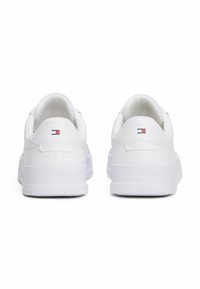 Sneaker in pelle bianca con profilo basso, caratterizzate da una finitura liscia, punta arrotondata, collare alla caviglia imbottito e un piccolo logo rosso, bianco e blu sul tallone.