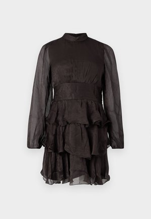 Rochie lungă neagră din material transparent, cu mâneci lungi, decolteu înalt, talie plisată și fustă cu volane suprapuse, pe un fundal alb simplu.