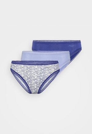 Biały rybaczek z prążkowanego materiału z cienkimi ramiączkami, sparowany z wzorzystymi majtkami bikini z niebieskimi wykończeniami oraz abstrakcyjnymi wzorami w granacie i bieli.