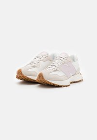 Des chaussures de sport claires présentent un mélange de daim et de matériaux synthétiques, avec une touche de rose, une semelle texturée et un design à lacets.