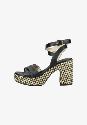 Sandale à talon haut en cuir noir avec une épaisse semelle plateforme tissée beige et noire et une bride de cheville avec boucle.