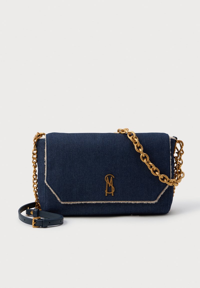 Borsa a tracolla in denim blu scuro con tracolla in catena dorata e accento in pelle. Presenta una cucitura a contrasto e un dettaglio con logo sulla parte frontale.