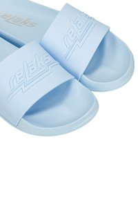 Lichtblauwe slipper sandalen van gestructureerd rubber, met een brede band waarop het woord "relaks" is geperst in een contrasterend ontwerp.