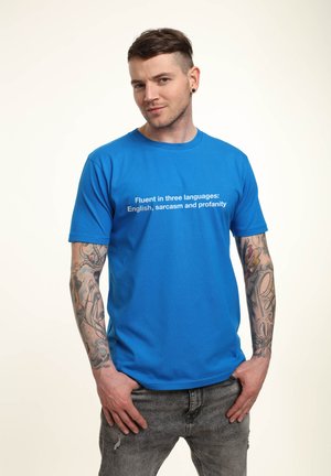 Camiseta de algodón azul con mangas cortas que presenta un texto blanco que dice: "Hablo tres idiomas: inglés, sarcasmo y groserías."