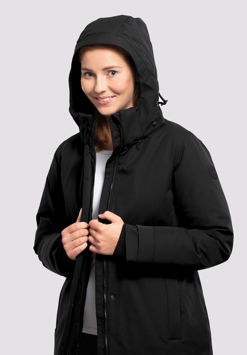 Chaqueta impermeable negra con cremallera frontal y botones de presión, que cuenta con capucha y bolsillos laterales, hecha de un tejido suave y texturizado.