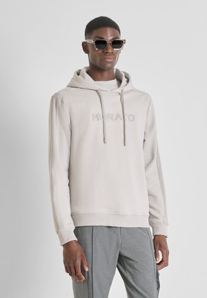 Sudadera gris clara con capucha y logo bordado "MORATO" en el pecho. Cuenta con puños y dobladillo acanalados, combinada con pantalones grises y gafas de sol.