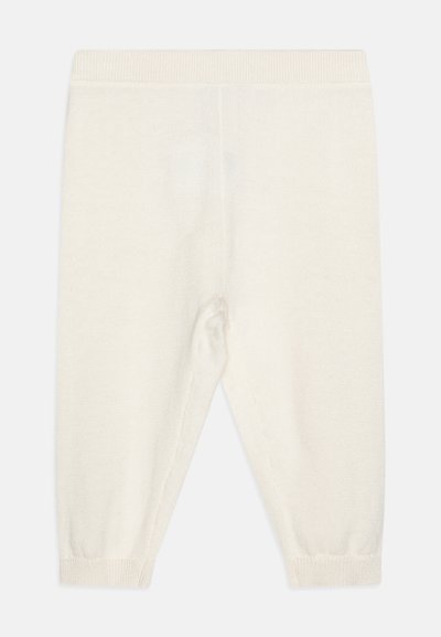 Krēmkrāsas adītas bikses ar ribotu jostu un aprocēm. Mīksta tekstūra, taisnas kājas dizains, bez rakstiem vai rotājumiem.