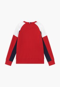 Rotes Sweatshirt mit weißen und marinefarbenen Raglanärmeln, rundem Ausschnitt und gerippten Bündchen. Glatte Textur, keine sichtbaren Muster oder Grafiken.