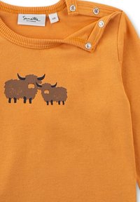 Oranges Baby-Bodysuit mit braunen Cartoon-Hochlandrindern auf der Brust und Druckknöpfen an der Schulter.