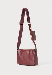 Borsa a tracolla in pelle borgogna con motivi floreali in rilievo, hardware color oro, una pochette con zip removibile e tracolla regolabile.