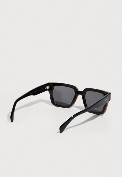 Négyzet alakú napszemüveg fekete kerettel és piros díszítéssel, szürke lencsékkel és fényes felülettel. A szárak karcsúak és keskenyedők.