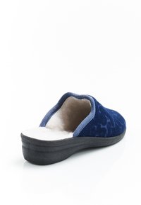 Ciabatta blu navy con un interno morbido e peloso, tacco basso e materiale esterno testurizzato. Design slip-on con suola liscia.