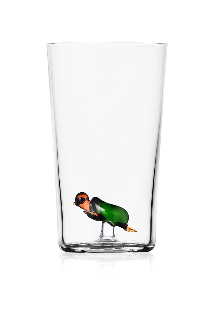 Przezroczysta szklanka o kolorowym szkle przedstawiającym ptaka wewnątrz, w odcieniach czerni, zieleni i pomarańczu.