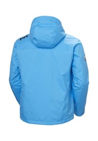 Blauwe waterdichte jas met capuchon, met een gladde textuur, zonder zichtbare sluitingen, en een logo op de bovenste linkerschouder.
