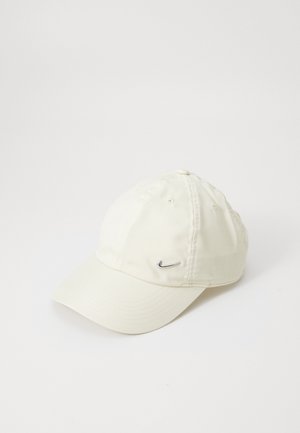 Gorra blanca de Nike con una tela suave, visera curva, diseño de seis paneles y un pequeño logotipo plateado en el lado izquierdo frontal.