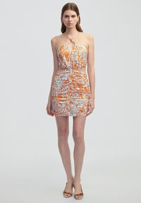 Oranje en blauwe patroon halterjurk met een uitsnijding, cinched taille en korte rok. Materiaal lijkt lichtgewicht te zijn met een gestructureerde afwerking.