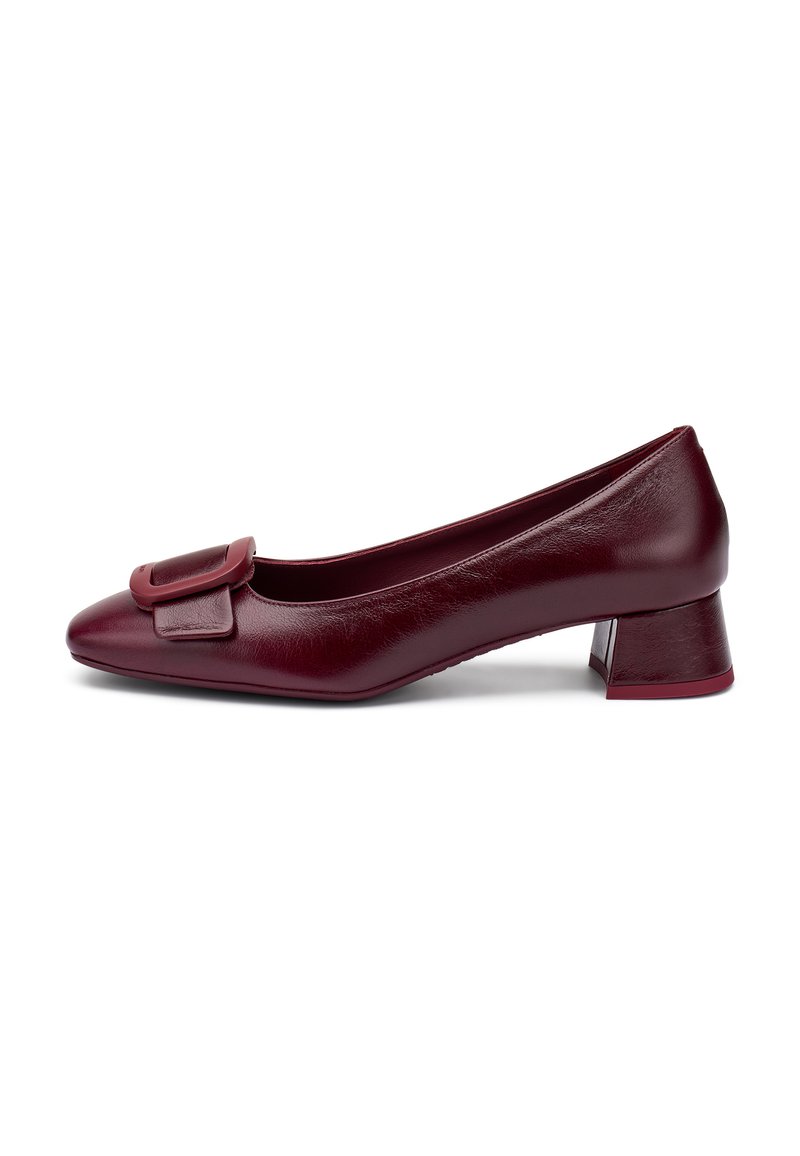 Chaussure pour femme en cuir bordeaux à talon bas avec un bout carré et une grande boucle décorative à l'avant, vue de côté sur fond blanc.