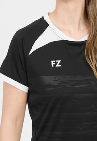 Svart atletisk t-shirt med korta ärmar, vita detaljer på kragen och axlarna, med ett subtilt grafiskt mönster och "FZ"-logotyp.