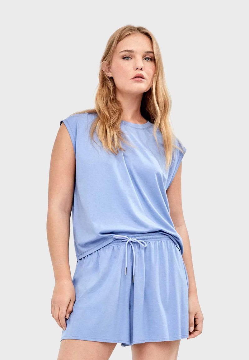 Haut sans manches bleu clair à coupe décontractée, assorti à un short à taille élastique avec cordon de serrage. Tissu doux et lisse.