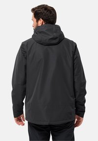 Zwarte waterdichte jas met een capuchon, gladde textuur en een relaxte pasvorm. Heeft een zoom die onder de taille valt en verstelbare manchetten.