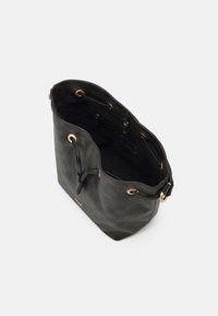 Borsa a secchiello in tela a quadri marrone con occhielli dorati, dettagli in pelle nera e un ampio interno in tessuto nero.