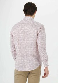 Langsleeveshirt met een roze geometrisch patroon op een lichte achtergrond, met een puntkraag en knoopmanchetten. Aansluitende pasvorm.