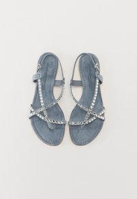 Sandales en daim bleu avec des brides croisées ornées de strass transparents. Le design à semelle plate améliore le confort, avec une sangle de cheville ajustable.