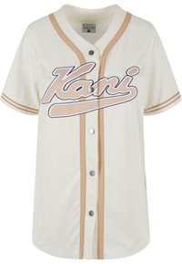 Maglietta da baseball crema con strisce beige, chiusura con bottoni e "Kani" ricamato in bianco. Realizzata in tessuto traspirante per il massimo comfort.