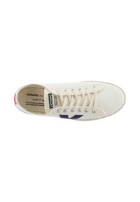Witte canvas sneaker met marineblauw logo, ronde neus en witte veters. Inclusief rode accent op de hiel en branding op de binnenzool.