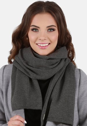 Bufanda gris oscuro hecha de material de punto, con una textura suave y un diseño sencillo, llevada de forma casual alrededor del cuello.
