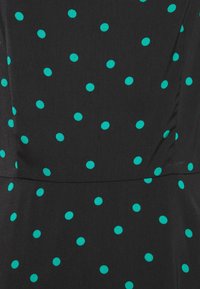 Černá látka s tyrkysovými puntíky, mírně texturovaná. Vzor se skládá z pravidelně rozložených kulatých puntíků na hladkém povrchu.