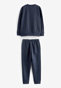 Set di felpa e pantaloni della tuta color blu navy. La felpa presenta un collo rotondo e polsini a costine; i pantaloni hanno un cinturino elastico in vita e polsini alle caviglie.