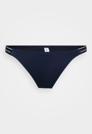 Navy blue Calvin Klein bikini bottom, made from soft stretch material, features a thin waistband with logo and seamless front and back design.