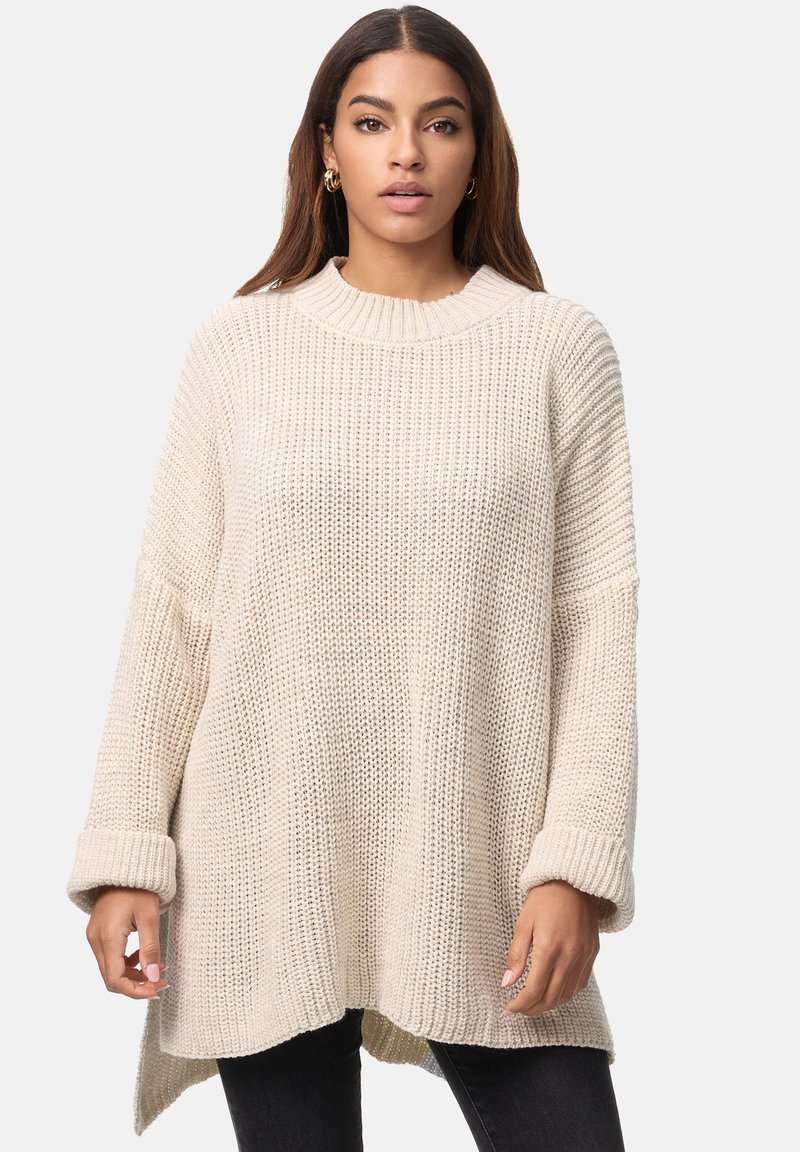 Dicker Strickpullover in Cremefarbe mit geripptem Textur, langen Ärmeln und weitem Ausschnitt. Mit asymmetrischem Saum und umgeschlagenen Ärmelabschlüssen.
