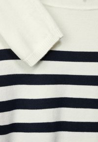 Polo a righe blu navy e bianche con una texture morbida, caratterizzato da un colletto classico e polsini a costine per una vestibilità aderente.