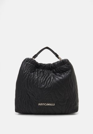 Sac en cuir noir avec texture matelassée, ouverture froncée et une poignée supérieure. Présente le logo doré "JUST CAVALLI" à l'avant.