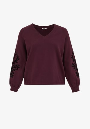 Burgundijas krāsas pulovers ar V veida kaklu, pūkainām piedurknēm un melnu ziedu izšuvumu uz piedurknēm. Mīksta auduma, brīva piegriezuma.
