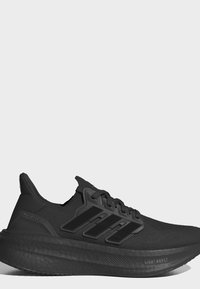Черен маратонка Adidas с три черни ивици, омекотена подметка, плетена горна част и релефна подметка на едноцветен светлосив фон.