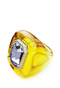 Anello in oro giallo con grande pietra preziosa blu a forma ottagonale circondata da piccoli diamanti trasparenti su sfondo bianco.