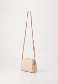 Borsa a tracolla in morbida ecopelle beige, forma rettangolare, tracolla regolabile, dettagli di cucitura discreti e design minimalista.