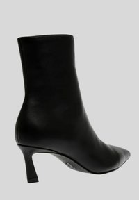 Stivaletto in pelle nera con punta affusolata e tacco sottile e alto. Presenta una texture liscia e un design minimalista.
